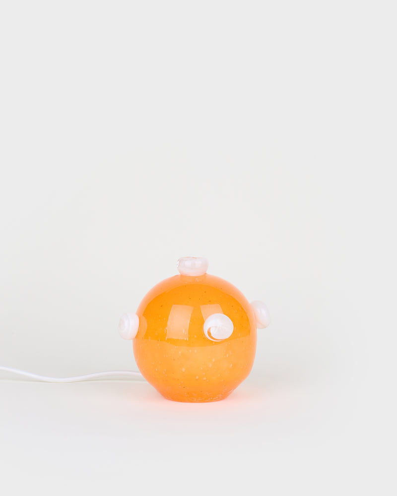 The little orange and white bedside lamp